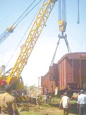 A crane lifts the damaged wagon