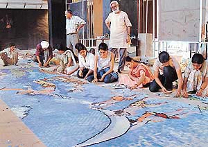 Students of the Government College of Arts work at a mural for the Delhi Metro Rail project on the college campus 