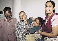 Ms Kuldip Kaur, Sub-Inspector, Women and Child Helpline, Chandigarh Police, (right) hands over Ravinder to his parents 