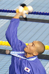 Japan�s Cho Sung-mo throws his Asian Games mascot to spectators after winning the silver medal in the men�s 1,500m freestyle 