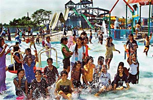 Children take a splash on the opening day of the Fun City carnival near Chandigarh 