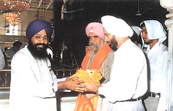 Punjab Director General of Police M. S. Bhullar being presented with a saropa by Giani Ranjit Singh, Head Priest of Gurdwara Sis Ganj Sahib