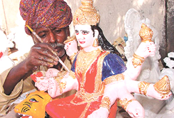 A roadside painter gives final touches to an idol of Durga