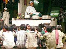 Slum dwellers wait outside a restaurant