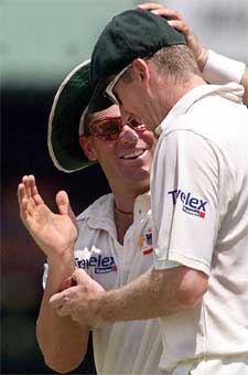 Australian spinner Shane Warne congratulates teammate Glenn McGrath