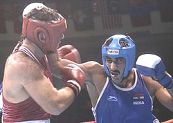 Harpal Singh (R) punches Mansour Ali of Lebanon during the preliminary boxing bout in the heavy weight 91kg category 