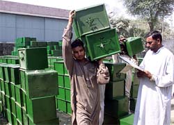 Workers in Lahore carry ballot boxes