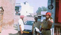 A cop hides his face as an accused turns his back on the camera