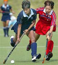 Anjum Saba of India and Naoko Saito of Japan vie for the ball during the Asian Games women�s hockey third place