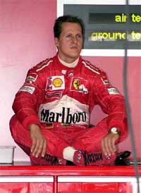 German Ferrari driver Michael Schumacher sits cross-legged in garage
