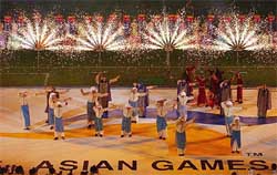 Young performers from Qatar dance in front of fireworks during the closing ceremony of the 14th Asian Games