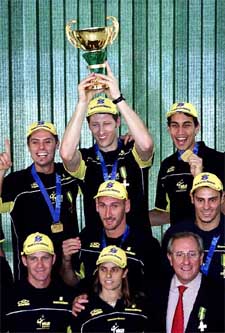 Brazilian volleyball player Gustavo Endres lifts the World Championship Trophy as he and other players and technical staff of the team pose for a photo