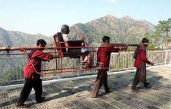 A pilgrim being carried on a palki