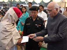 Deputy Prime Minister L. K. Advani presents a cheque to the widow of NSG commando