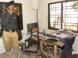 An officer stands inside a damaged police station after a parcel bomb exploded in Karachi