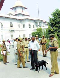 Policemen with a sniffer dog at the Patiala House Courts following a hoax bomb call 
