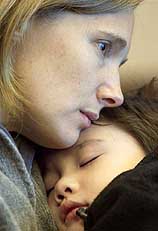 American Camille Colvin hugs her five-year-old son Griffin after they returned safely to Beijing from the central Chinese city of Zhengzhou on Friday 