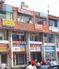 Enforcement staff of the Municipal Corporation, Chandigarh, remove hoardings and glow-sings in Sector 20 market in Chandigarh