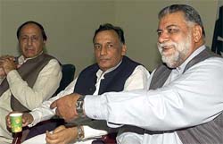 Mian Mohammad Azhar (centre), president of the Pakistan Muslim League (QA), Mir Zafarullah Jamali, party's Secretary-General (left) and Chaudhry Shujaat, parliamentary leader, attend a meeting