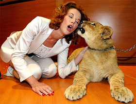 Television personality Rhonda Burchmore plays with a six-month-old lion cub
