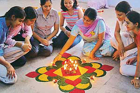 Participants give final touches to a rangoli