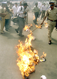 Policeman tries to extinguish a burning effigy