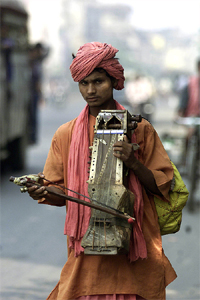 An Indian holy man plays a traditional musical instrument