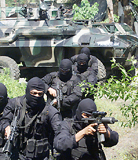 Soldiers from the Anti-Crime Task Force (ACTAF), run away from an armoured personnel carrier 