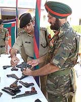BSF officials show the Pakistani-made pistols and ammunition