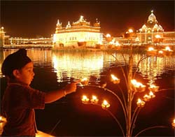 A child lights a lamp at the Golden Temple