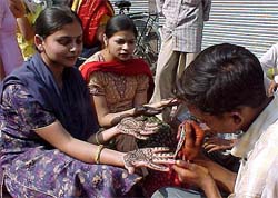 A woman gets mehendi applied on her hand