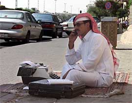 Practicing a centuries-old service, Abdullah, a young Saudi writer for hire, squats before the modern tools