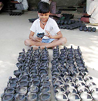 A child labourer busy making decorative earthen lamps