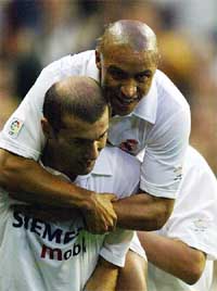 Real Madrid's Brazilian Roberto Carlos jumps on French Zinedine Zidane to celebrate a goal