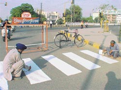 Painters repaint road lines and zebra crossings as part of a programme to recondition of roads
