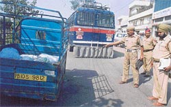 Cops examine the site of an accident in which two persons were run over by a police bus
