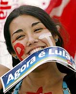 A supporter of Brazilian presidential candidate Luiz Inacio Lula da Silva holds in her teeth Lula bumper stickers