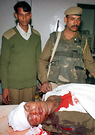 Security personnel stand near the dead body of their colleague