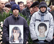 Russian boys hold portraits of Arseny Kurilenko and Kristina Kurbatova