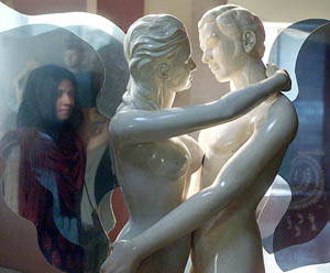 A visitor's image is reflected on a statue