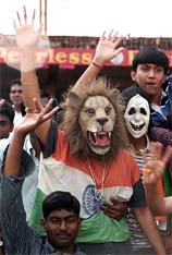 Spectators wearing masks of lion enjoy the third day of the final cricket Test
