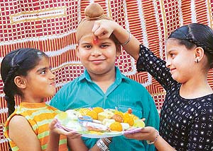 A girl applies tilak on her brother�s forehead on the occasion of Bhai Dooj