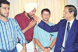 Prof K.N. Pathak, Vice-Chancellor, offers sweets to the new office-bearers of the Panjab University Campus Students Council in Chandigarh on Thursday.