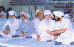 Mr Milkiat Singh Birmi, MLA, explains a point to PCC chief H.S Hanspal at a convention of the Vishwakarma Ramgarhia Council of India 