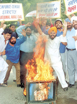 National Akali Dal chief Paramjeet Singh Pamma and activists burning a TV set