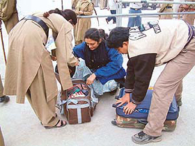 Police personnel check the luggage of the devotees at the main entrance of Golden Temple in Amritsar on the eve of the SGPC election on Monday. 