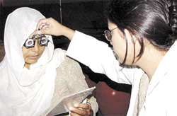 An eye specialist checking a patient at 'All Ages...One Spirit'