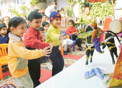 Kids enjoy a puppet show at �Kids Carnival� in St Xavier Playway School