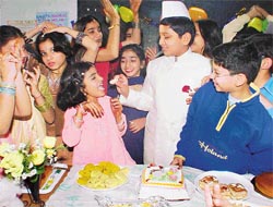 Chacha Nehru cuts a cake: A student of KVM School dressed up like Pandit Jawaharlal Nehru offers cake to his friends