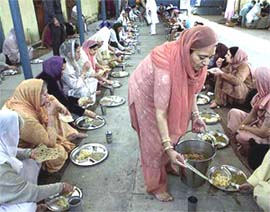 Sikh families from England enjoy a �langar� at Darbar Sahib in Lahore